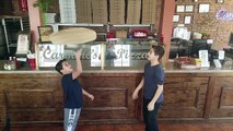 Deux enfants font tourner de la pâte pizza