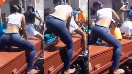 Des filles font du twerk au-dessus d'un cercueil