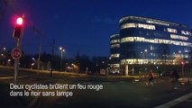 Deux cyclistes brûlent un feu rouge dans le noir sans lampe