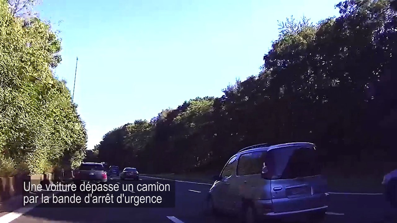 Une voiture dépasse un camion par la bande d'arrêt d'urgence