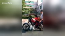 Girl drives father's motorcycle on road in China