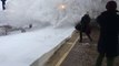 Un train entre en gare et recouvre les passagers de neige. Impressionnant!