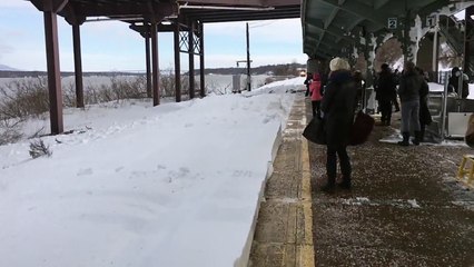Un train éclabousse de neige des voyageurs qui attendaient sur le quai