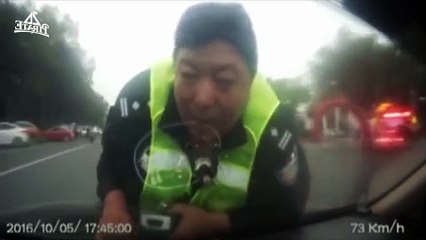 Un policier s'accroche à une voiture pour l'arrêter