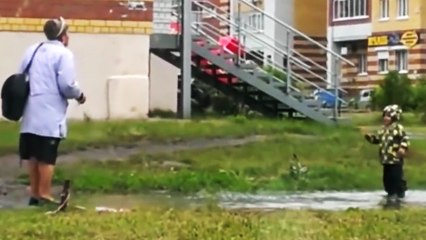 Un enfant joue dans une flaque d'eau