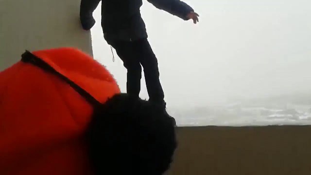 Ce gamin totalement inconscient est en équilibre sur le rebord d'un balcon au 25eme étage