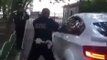 Un policier russe essaye de casser la vitre d'un BMW