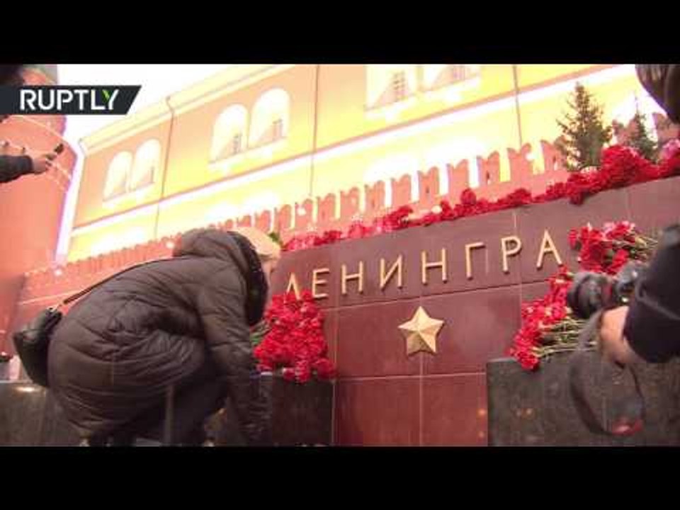 People bring candles & flowers at Leningrad Hero City monument in Moscow