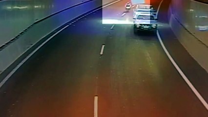 Un motard se prend un matelas qui s'envole d'une remorque dans un tunnel.