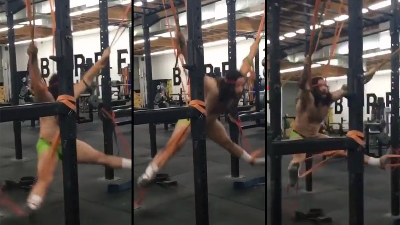Cet homme s'entraine avec des élastiques dans une salle de sport..