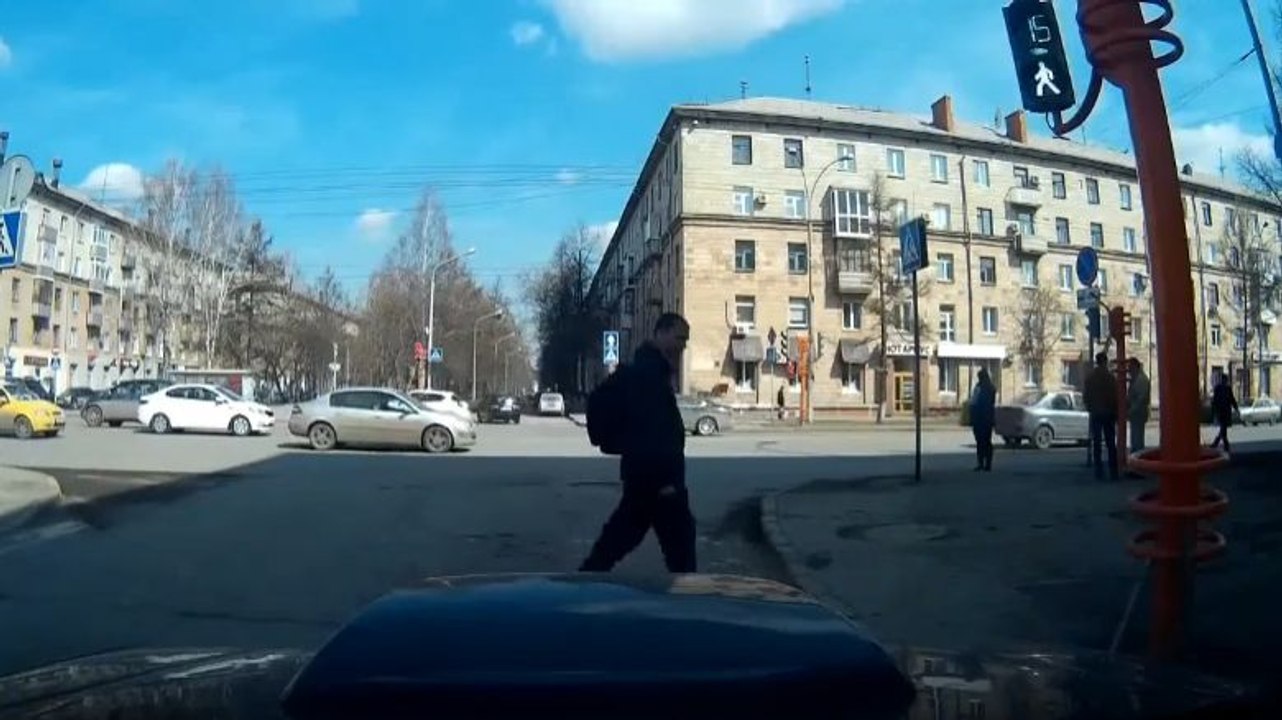 Un piéton redresse un feu de signalisation