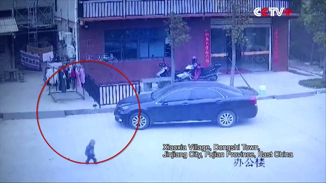 Un automobiliste au téléphone roule sur un petit garçon