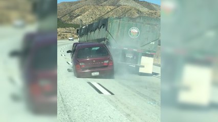 下载视频: Un camion roule avec une voiture accrochée à sa remorque