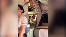 Sur la compagnie Emirates, une hôtesse surprise reversant du champagne d'un verre dans un bouteille