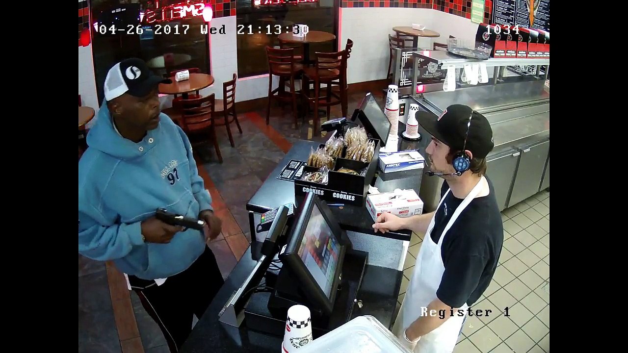 Un caissier incroyablement calme face à un pistolet pointé sur lui
