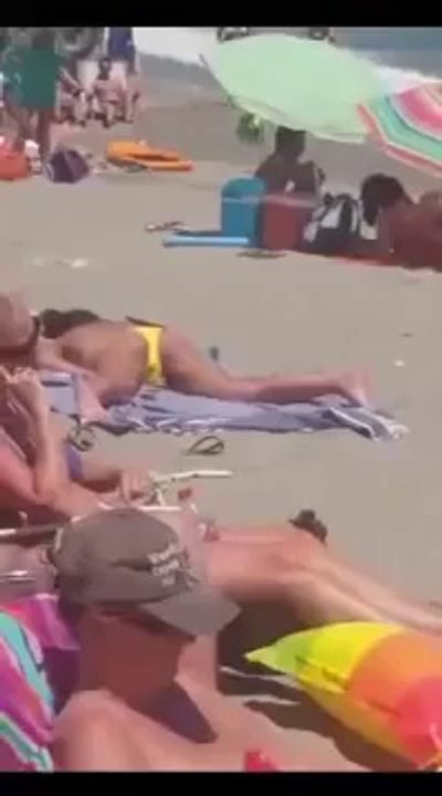 Cette femme seins nus surprise en train de se toucher sur une plage bondée sans se soucier des autres vacanciers autour d’elle !