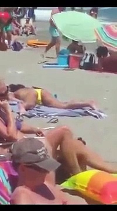 Cette femme seins nus surprise en train de se toucher sur une plage bondée sans se soucier des autres vacanciers autour d’elle !