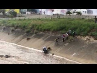 Caracas Protesters Form Human Chain to Pull Injured Man From River