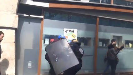 Un CRS frappe des manifestants à coups de matraque.