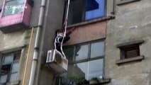 Firefighters rescue an elderly woman trapped on a window ledge