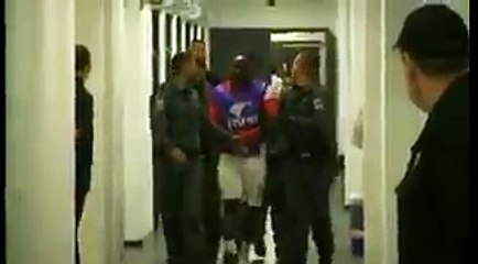 La police sort un joueur du vestiaire, les menottes aux mains