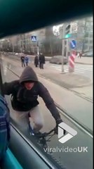 Ce taré s'accroche au tramway alors qu'il roule à vélo