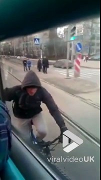 Ce taré s'accroche au tramway alors qu'il roule à vélo