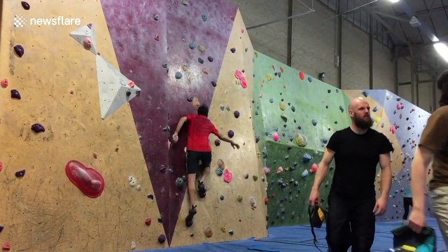 Climber scales indoor wall with no hands