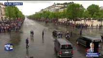 Macron redescend les Champs-Élysées, saluant la foule à travers le toit de sa voiture