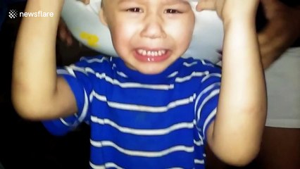 Boy gets toilet seat stuck on head