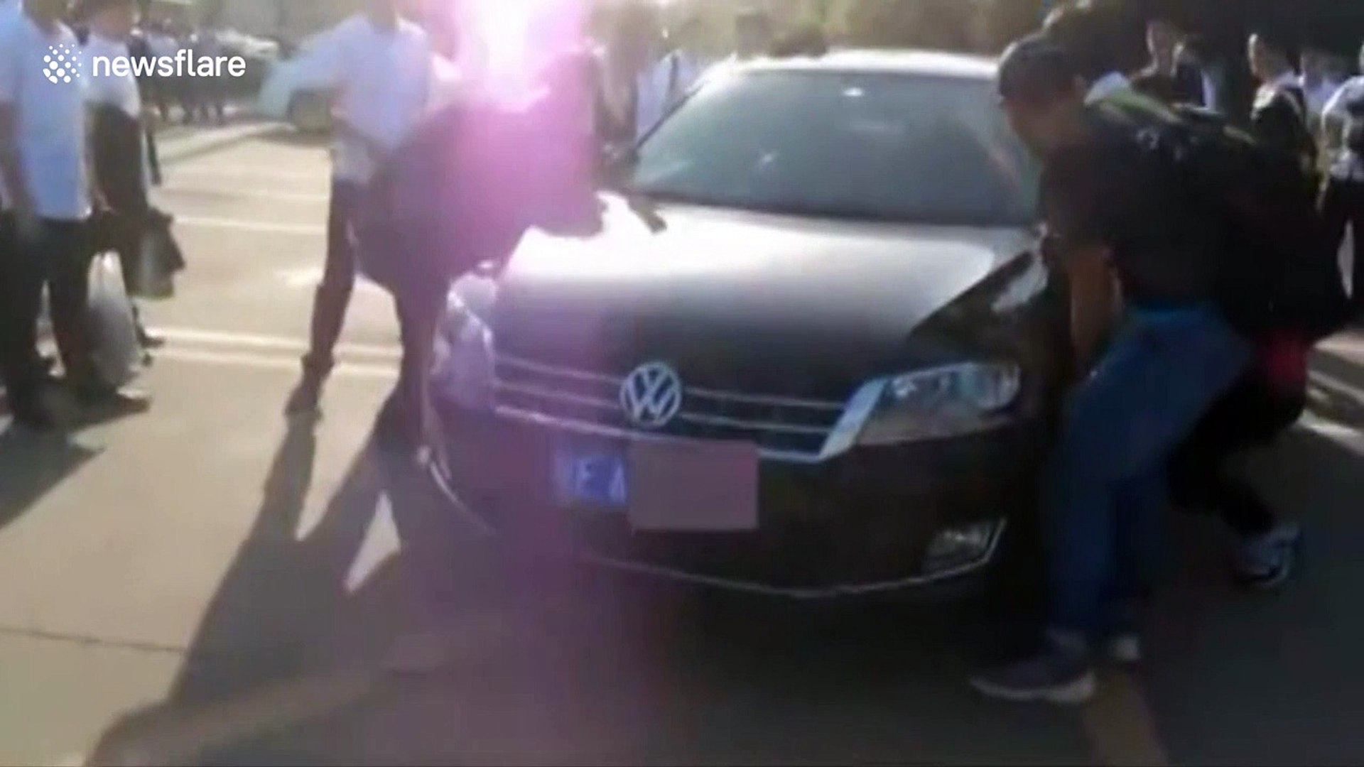 Students carry car out of the way for graduation picture