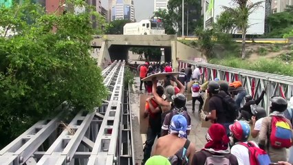 Protesters burn trucks as police use tear gas in Venezuela