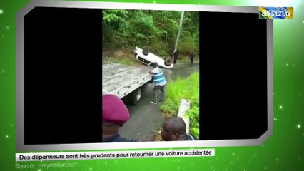 Des dépanneurs sont très prudents pour retourner une voiture accidentée