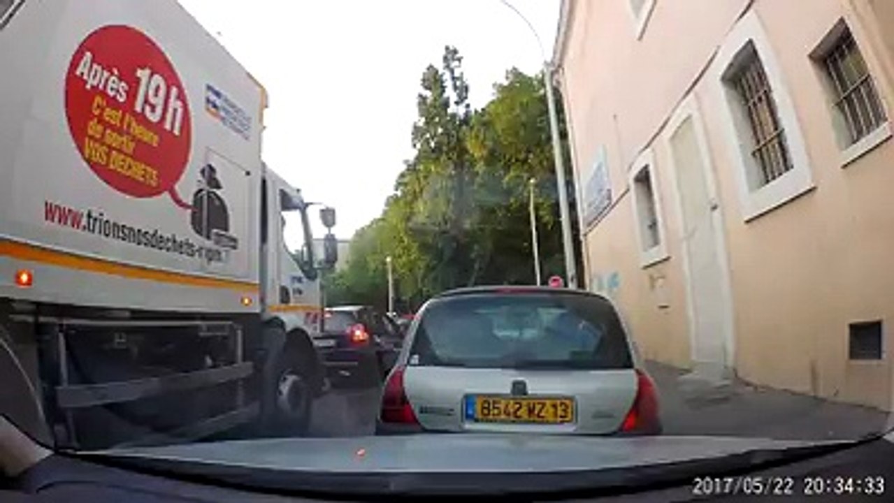 Un éboueur jette des déchets dans la rue (Marseille)