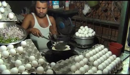 The man cooks the fried egg and gives it to the customer on the sandwich good job
