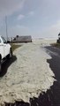Une route de bord de plage recouverte d'écume après une tempête en mer - Afrique du sud