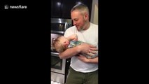 Baby doesn't like father's singing and plugs his ears