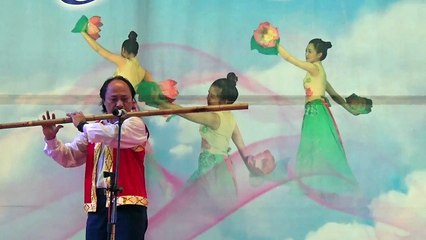 Vietnamese man playing very big flute