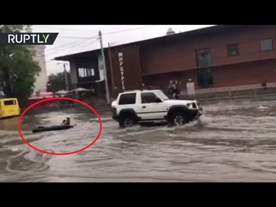 Never Bored: Kids surf through flooded streets behind SUV in Russia
