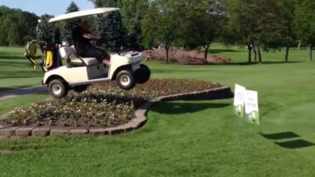 Il passe un parterre de fleur en voiturette de golf