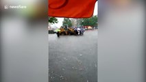 Digger driver charges two pounds a journey to transport commuters along flooded road