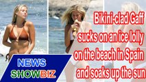Bikini-clad Gaff sucks on an ice lolly on the beach in Spain and soaks up the sun