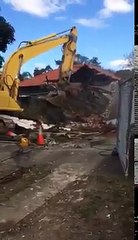 Un homme sous le godet d'une pelleteuse