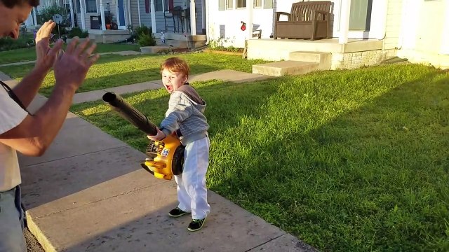 Un enfant super-vilain avec un souffleur de feuilles