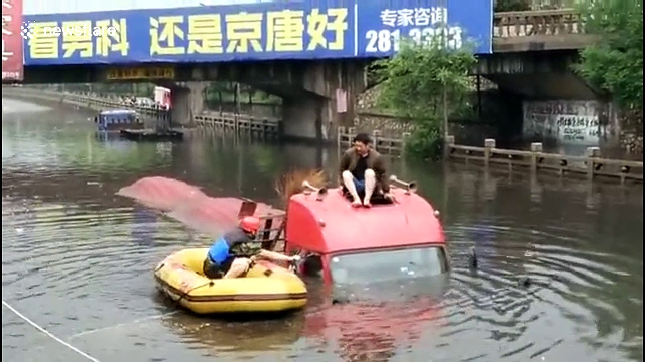 Firefighter uses dinghy to rescue lorry driver trapped on flooded road