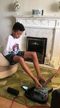 Un enfant sans bras joue Hold The Line à la guitare avec ses pieds.