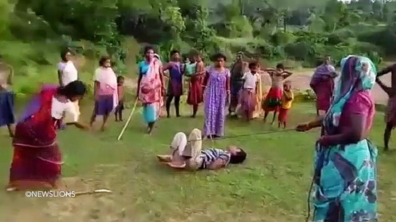 Women were filmed beating a man with sticks after he allegedly raped a child