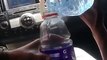 Un employé service-au-volant prend une bouteille d'eau en plein visage