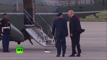 Trump struggles to retrieve marine hat blown off by the wind
