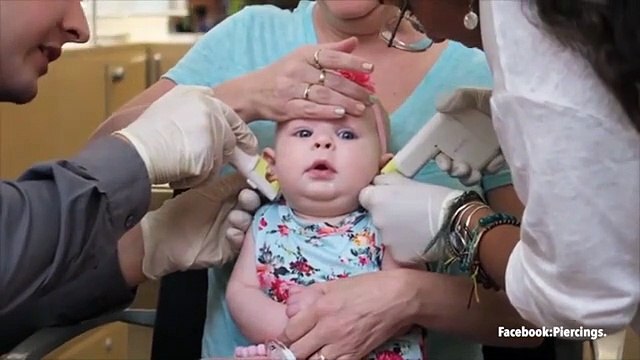 Mum is accused of child abuse after video of baby having her ears pierced sparks outrage on Facebook